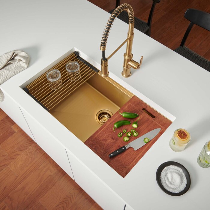 A bold brushed gold basin in the Giana collection shines in this light, bright kitchen with integrated roll-up rack and colander. Copyright: Ruvati
