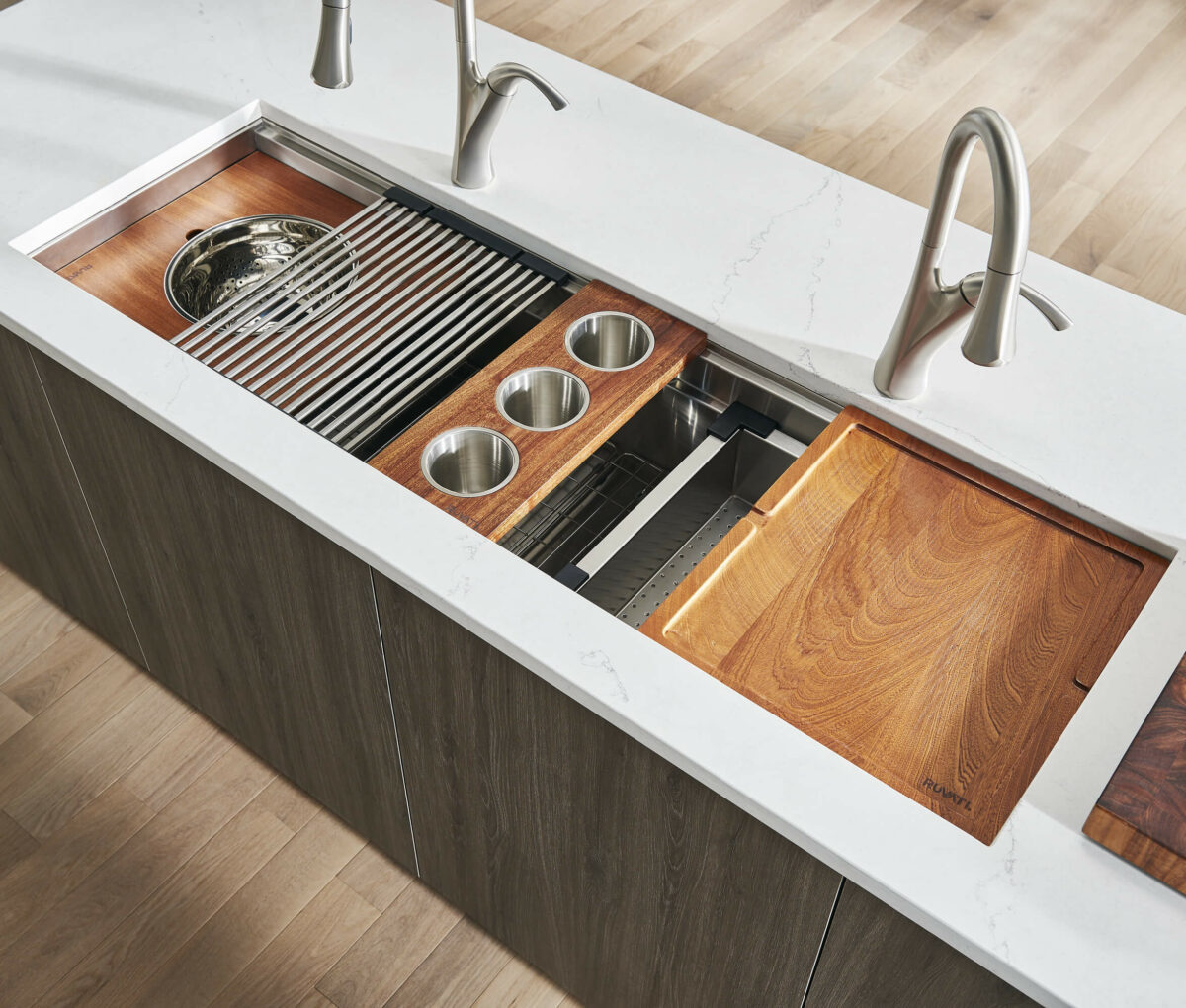 A close-up of the Nova sink's two-tiered system, featuring colander trays, utensil holders, and hardwood boards for unmatched flexibility. Copyright: Ruvati