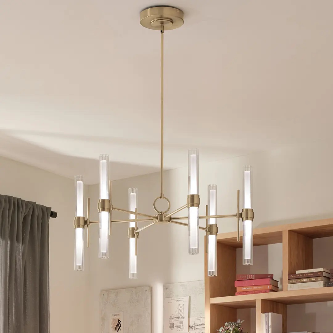 A kitchen workspace with an elegant chandelier featuring cylindrical glass shades, over a wood and white interior.
