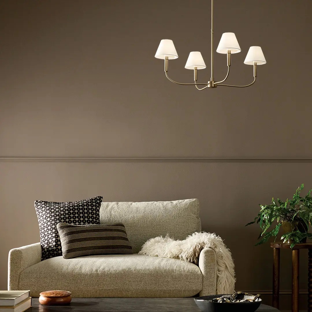 A cozy living area with a soft, gold-finished chandelier above a sofa, creating a warm atmosphere.