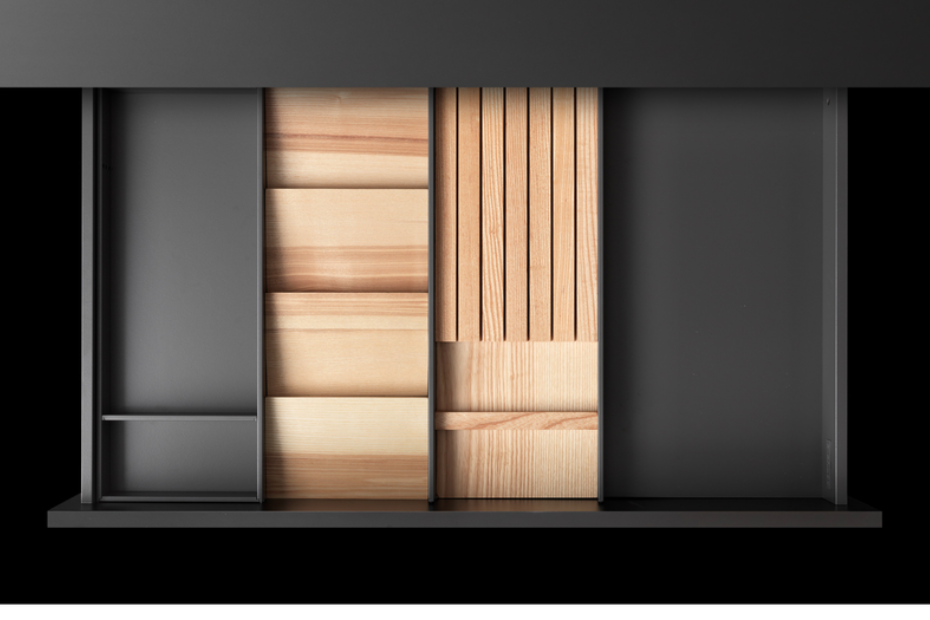 Top view of a GRASS Tavinea drawer insert with wood and steel modules arranged for modular storage.