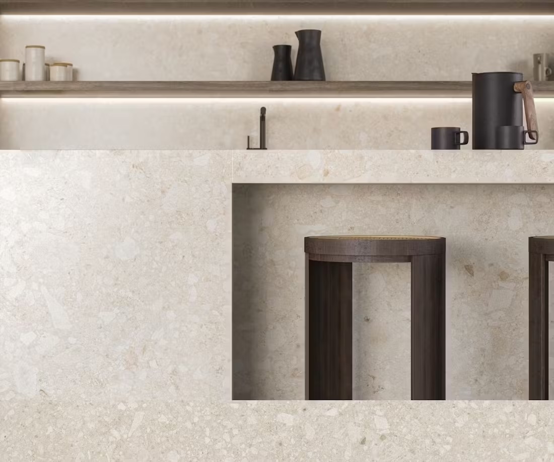 Open-plan kitchen featuring a stone island with seating, warm wood cabinetry, and a clear pathway leading toward the dining area.