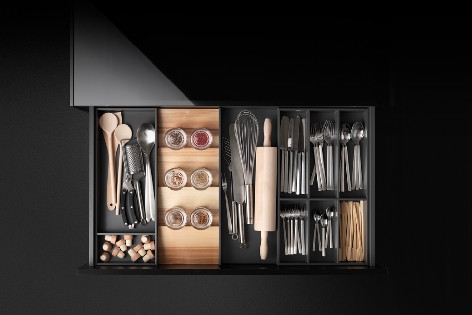Open drawer with a GRASS Tavinea organizer containing cutlery, spices, utensils, and baking tools.
