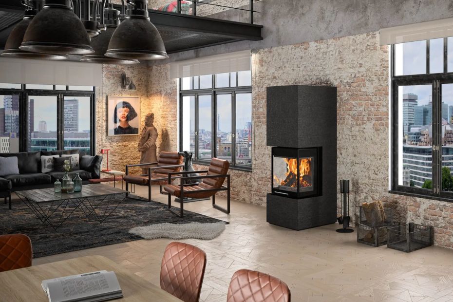 Loft Space with Exposed Brick Wall, Armchair, and ORANIER Club UH-550 Fireplace in a Dark Finish; Visible Flames in the Wood Stove.