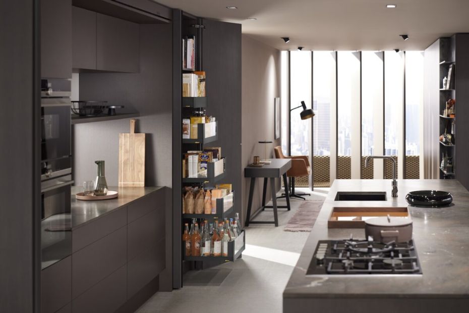 Tall pantry cabinet with full-extension pull-outs holding bottles, dry goods, and packaged foods.