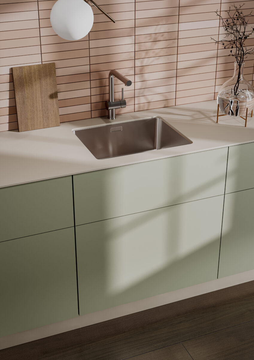 Modern kitchen with sage green cabinets, apricot backsplash, stainless steel sink, and clean contemporary lines